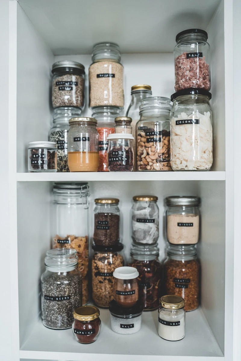 pantry filled with glass jars with black labels