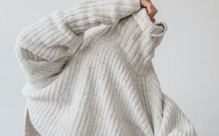 person tkaing off their white polo sweater