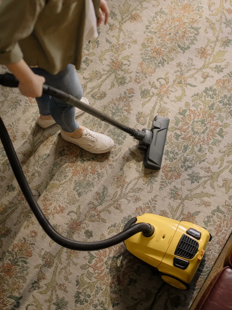 person vacumming a rug