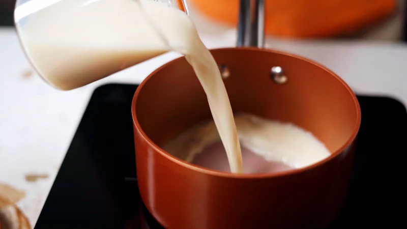 poring coconut milk into pot