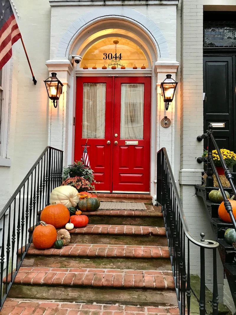 red door with different types of pumpkins