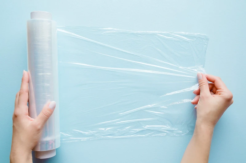 roll plastic wrap on blue background