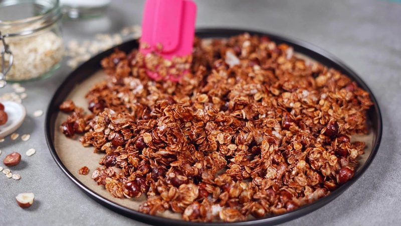 spreading out granola mix on a sheet pan