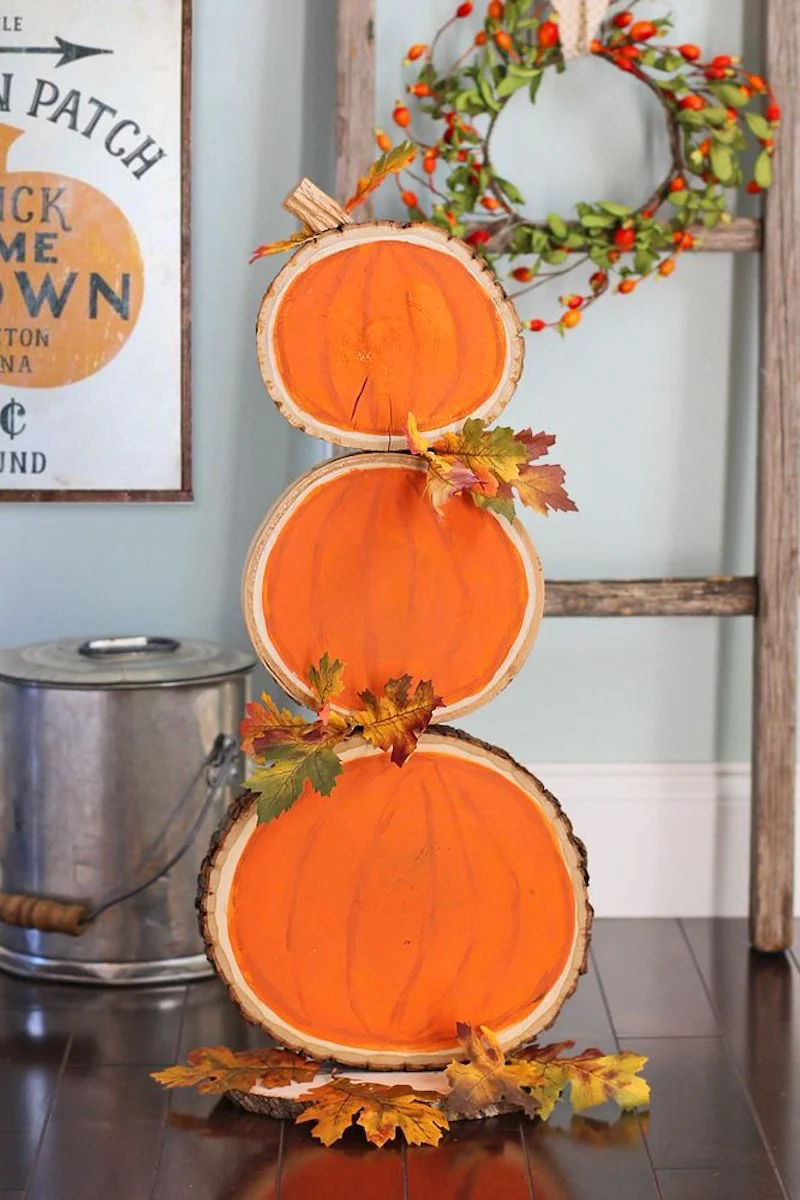 three wooden circles with painted on pumpkin
