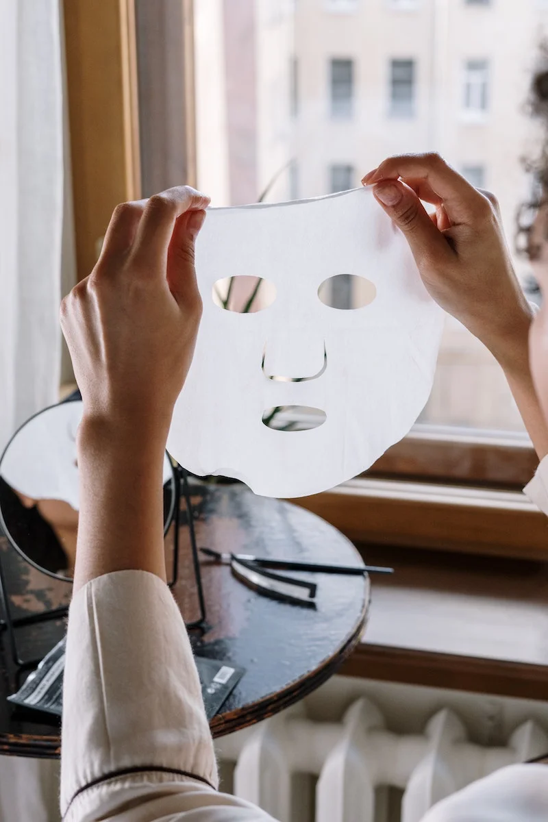 two hands holding a sheet mask