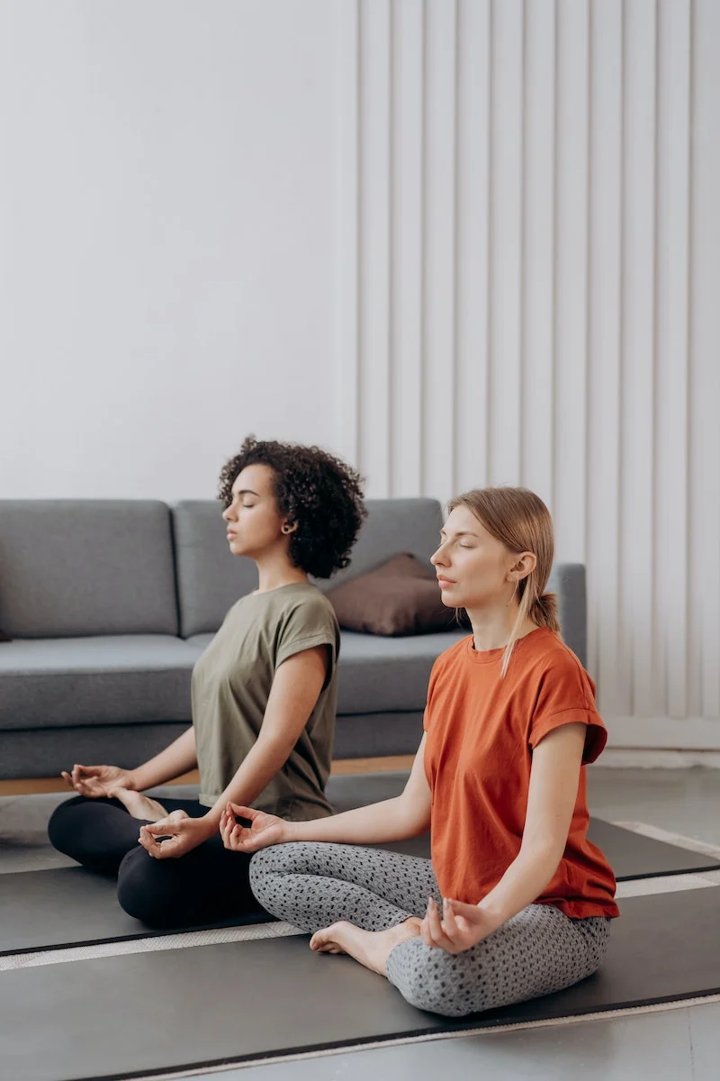 two women meditating on the floor