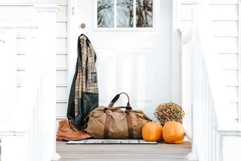 white door with pumpkins and shoes and bag