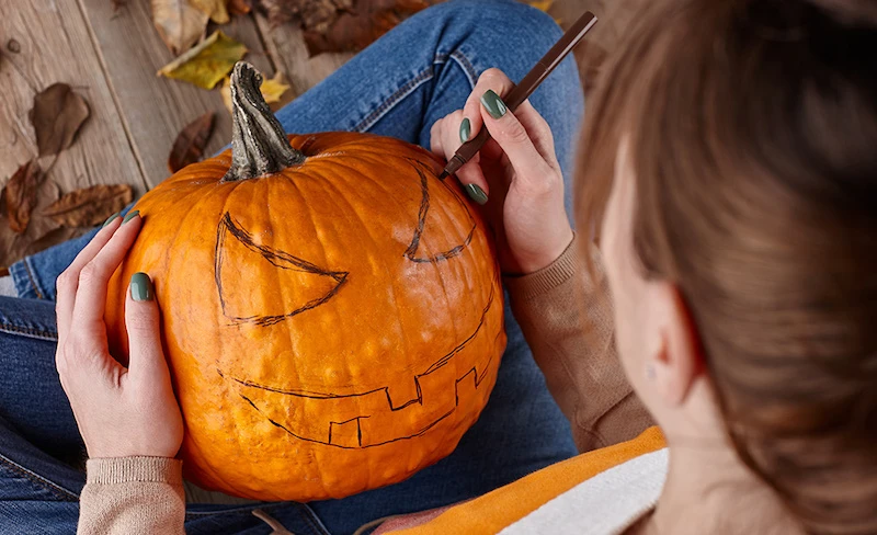 woman drawing on design for pumpkin