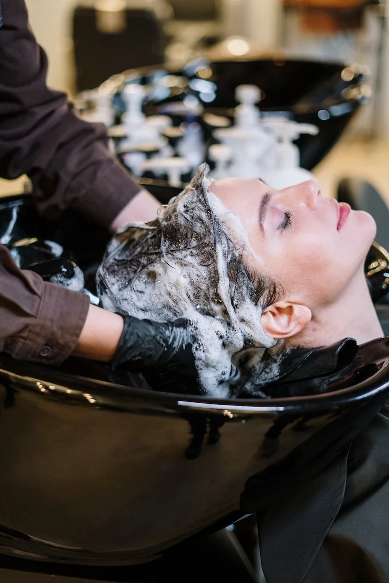 woman getting her hair washed at a salon