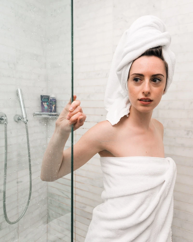 woman getting out of the shower with towel on head