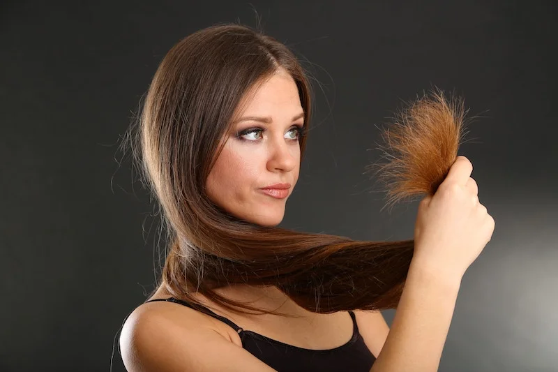 woman holding her damaged hair