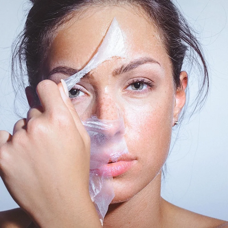 woman removing a peel off mask