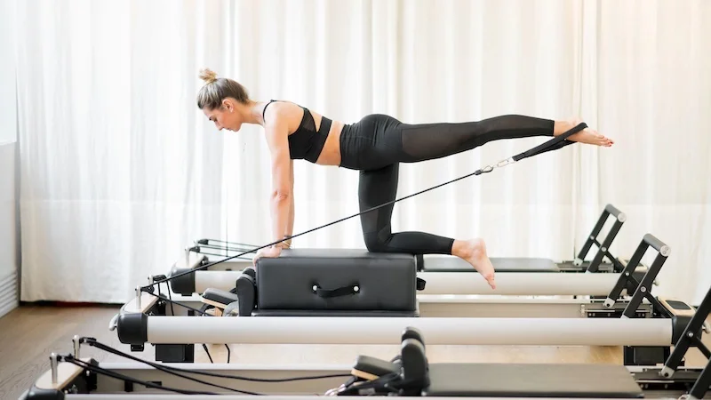 woman usuing a pilates reformer