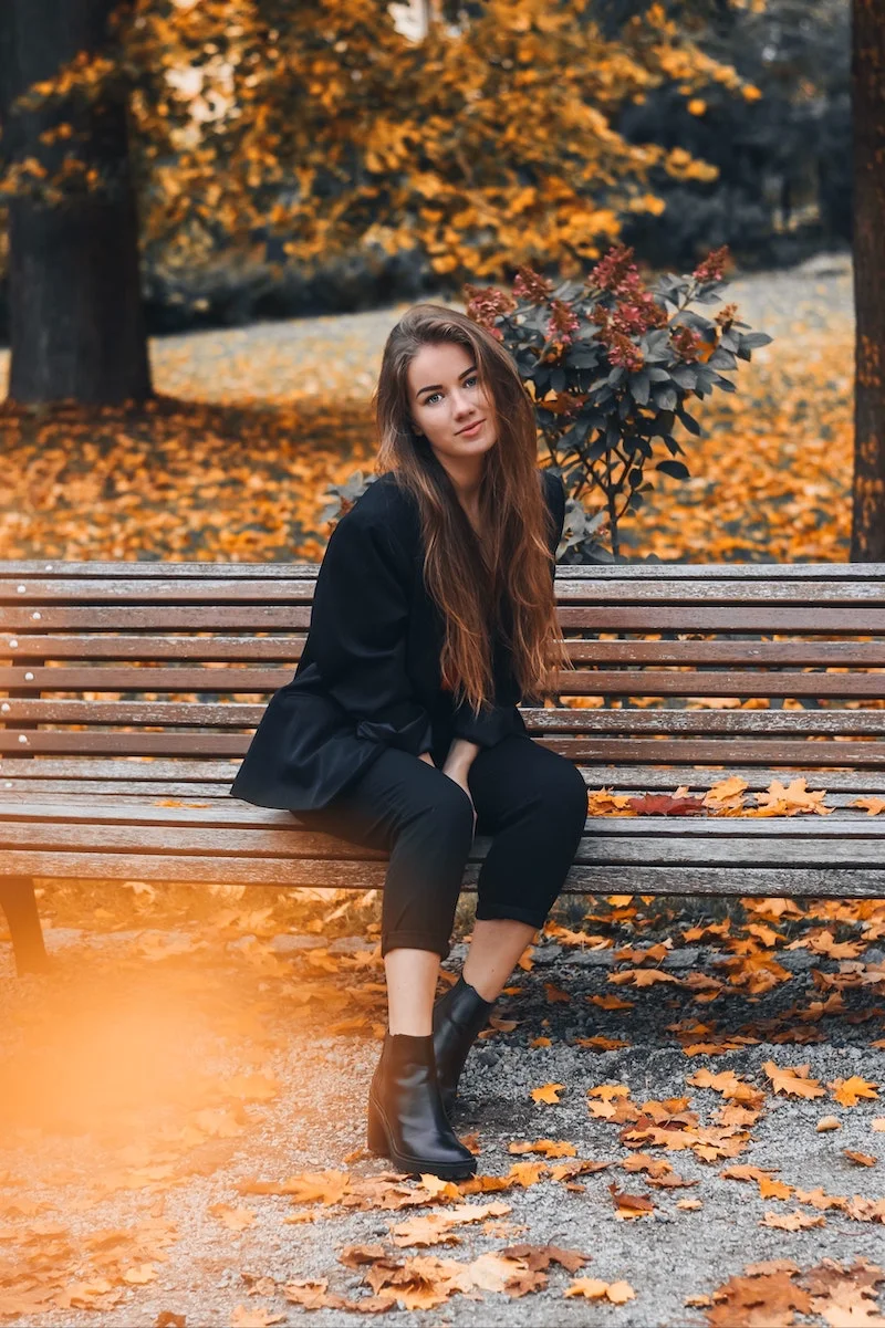 woman with long brown hair on bench