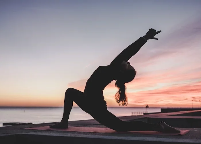 yoga vs pilates woman holding a yoga pose in sunset