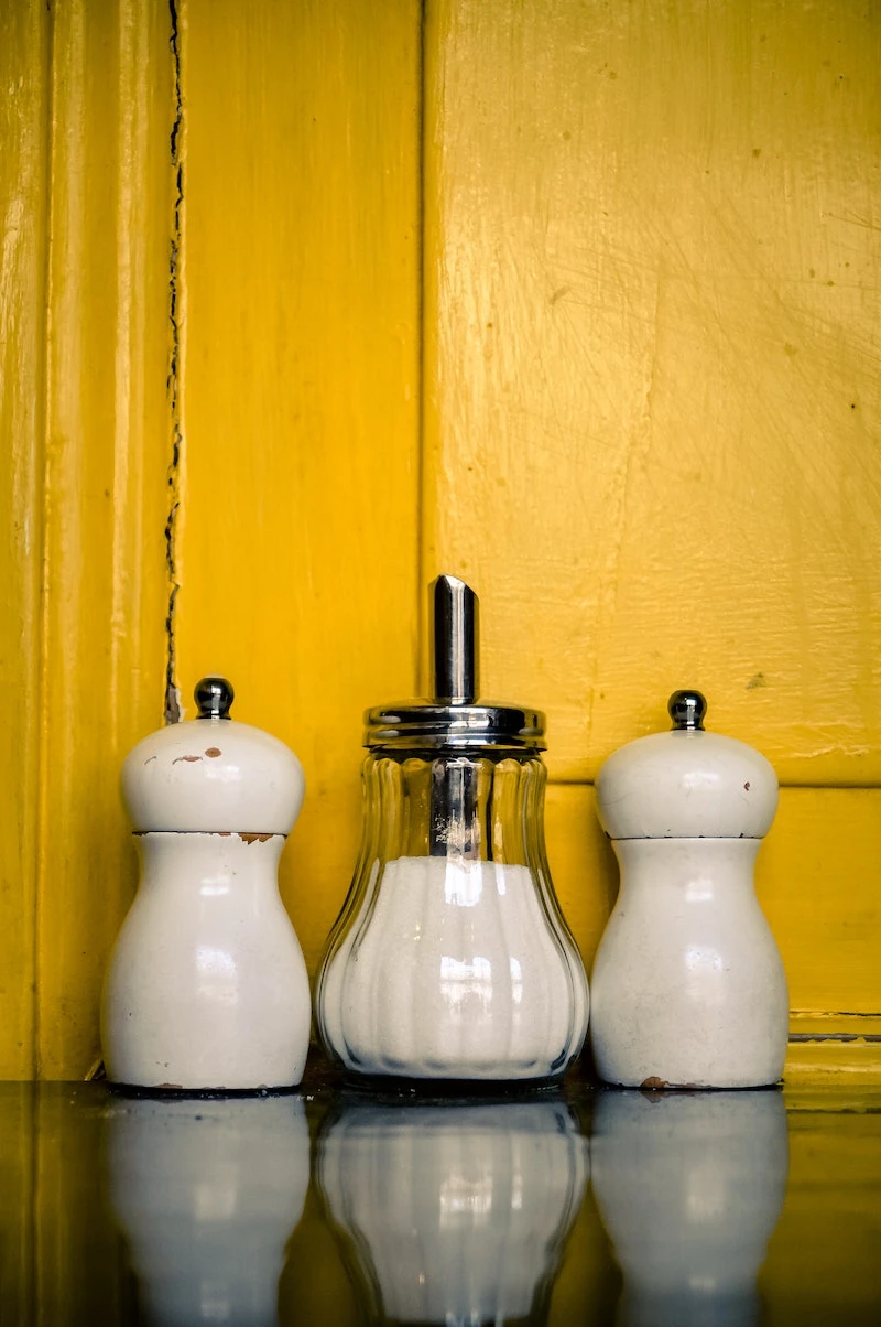 a salt jar on a yellow background