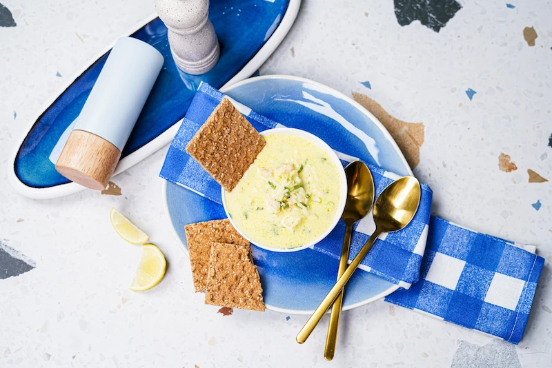 coconut shrimp soup with sesame crackers and golden spoons