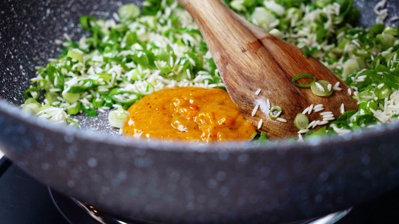 curry paste in a pan with green onions