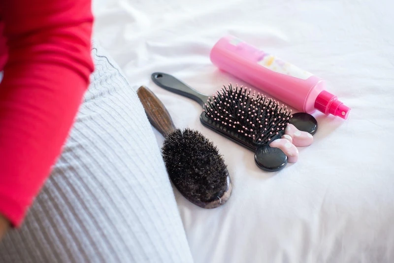 different hair brushes on a bed