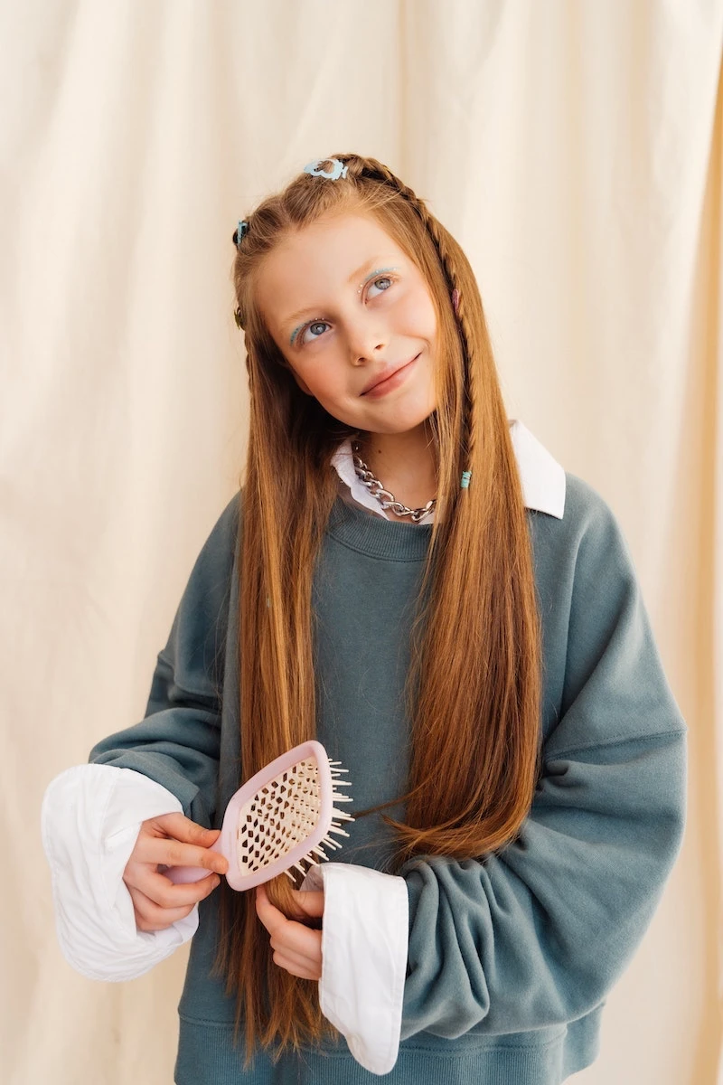 girl with orange hair brushing her hair
