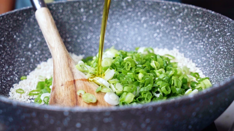 green onions and rice in a pan
