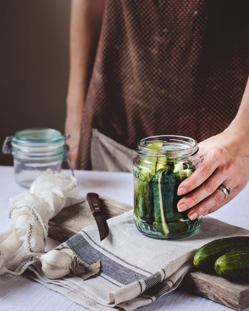 hand holding a jar of pickles