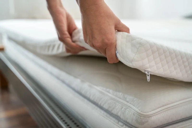 how to clean mattress topper hands holding a mattress topper
