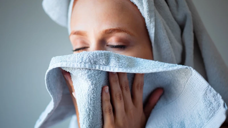 how to clear sinuses woman with towel to her face