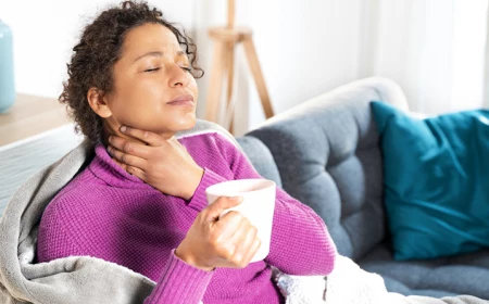 how to get rid of a sore throat woman holding her throat