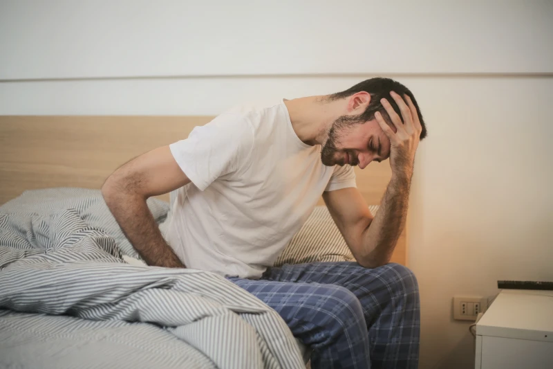 man sitting on theedge of his bed