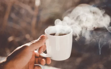 person holding a steaning cup of coffee