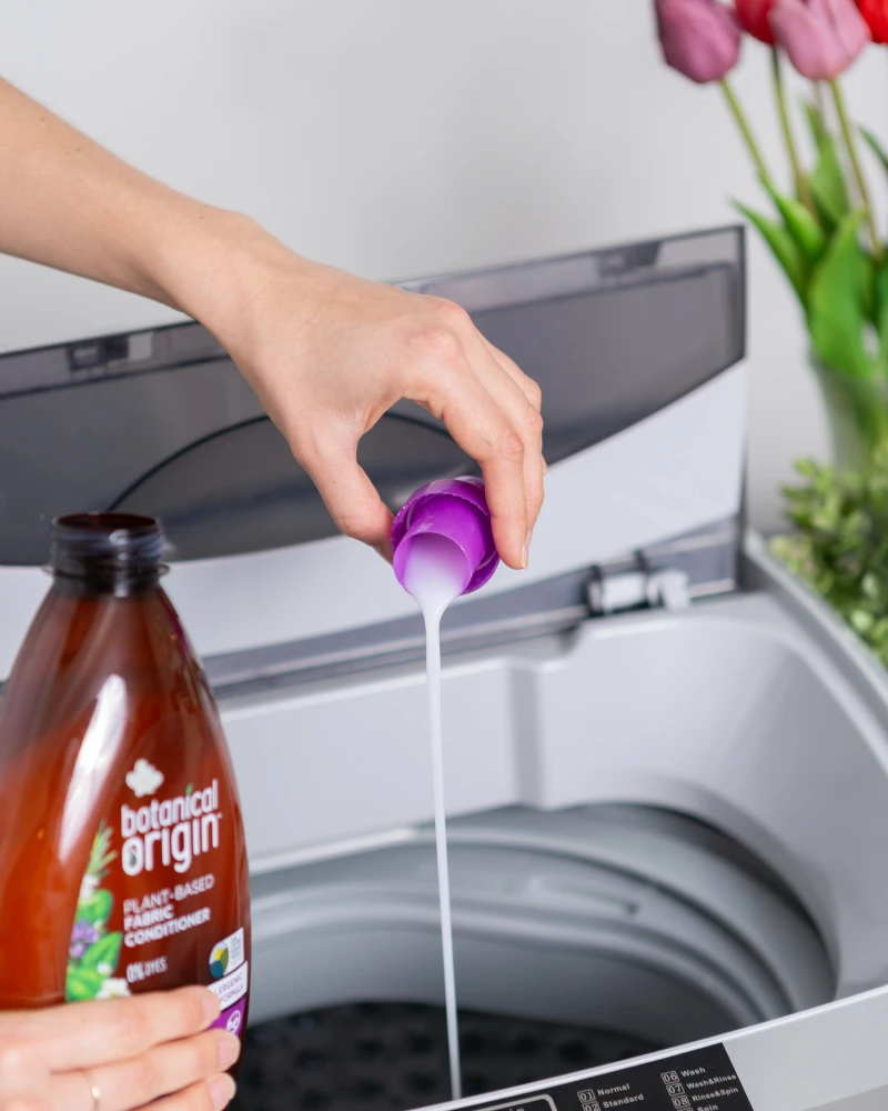 person pouring detergent in washing machine