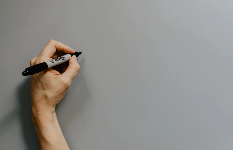 person preparing to write on wall with marker