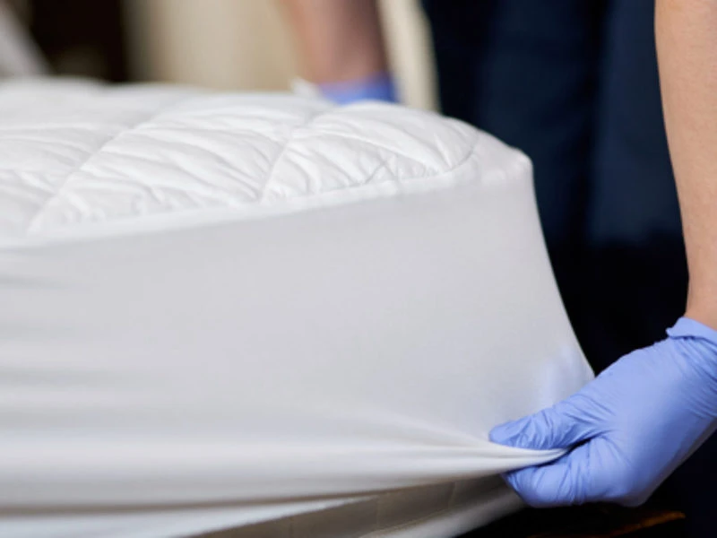 person putting a mattress protector