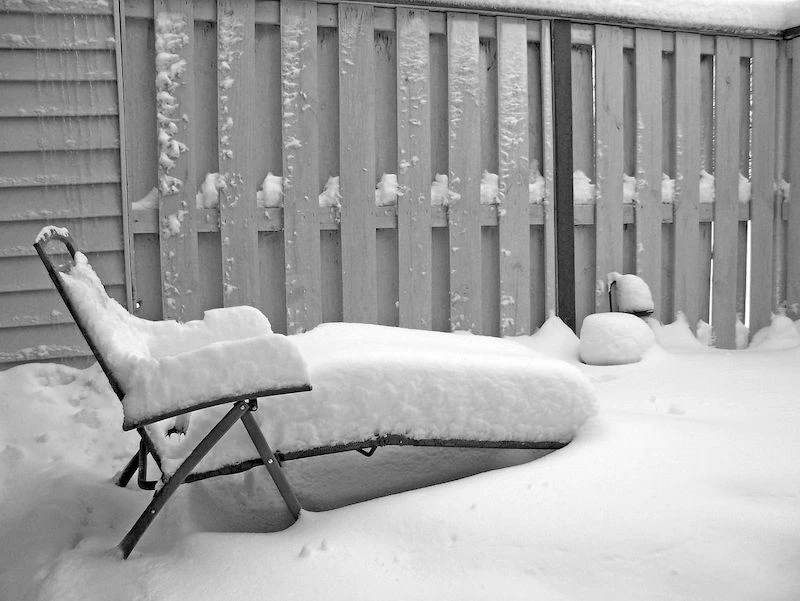 snow on a lounge chair outside