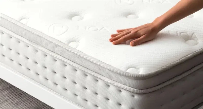 spring white mattress being touched by hand