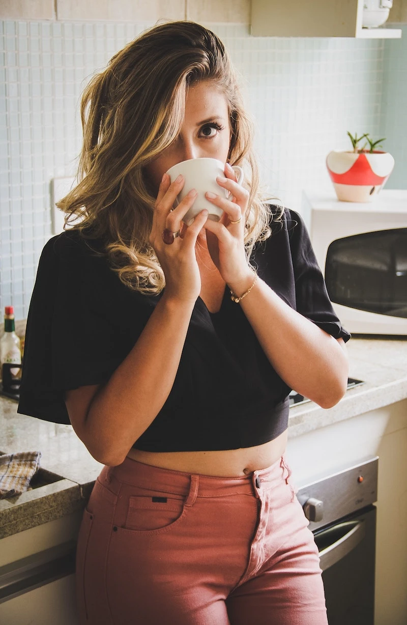 woman drinking coffee on the counter