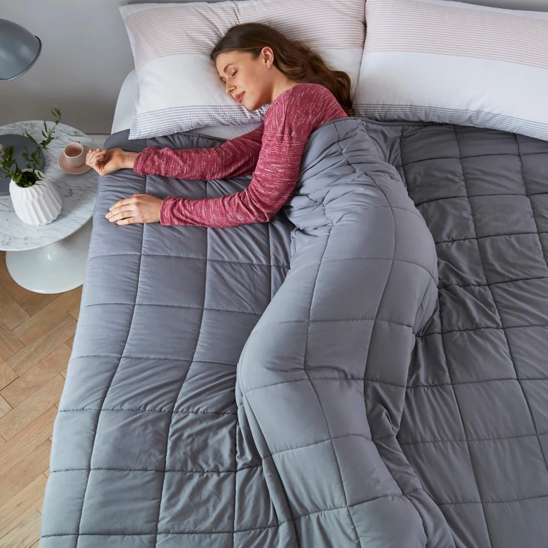 woman using a weighted blanket and sleeping