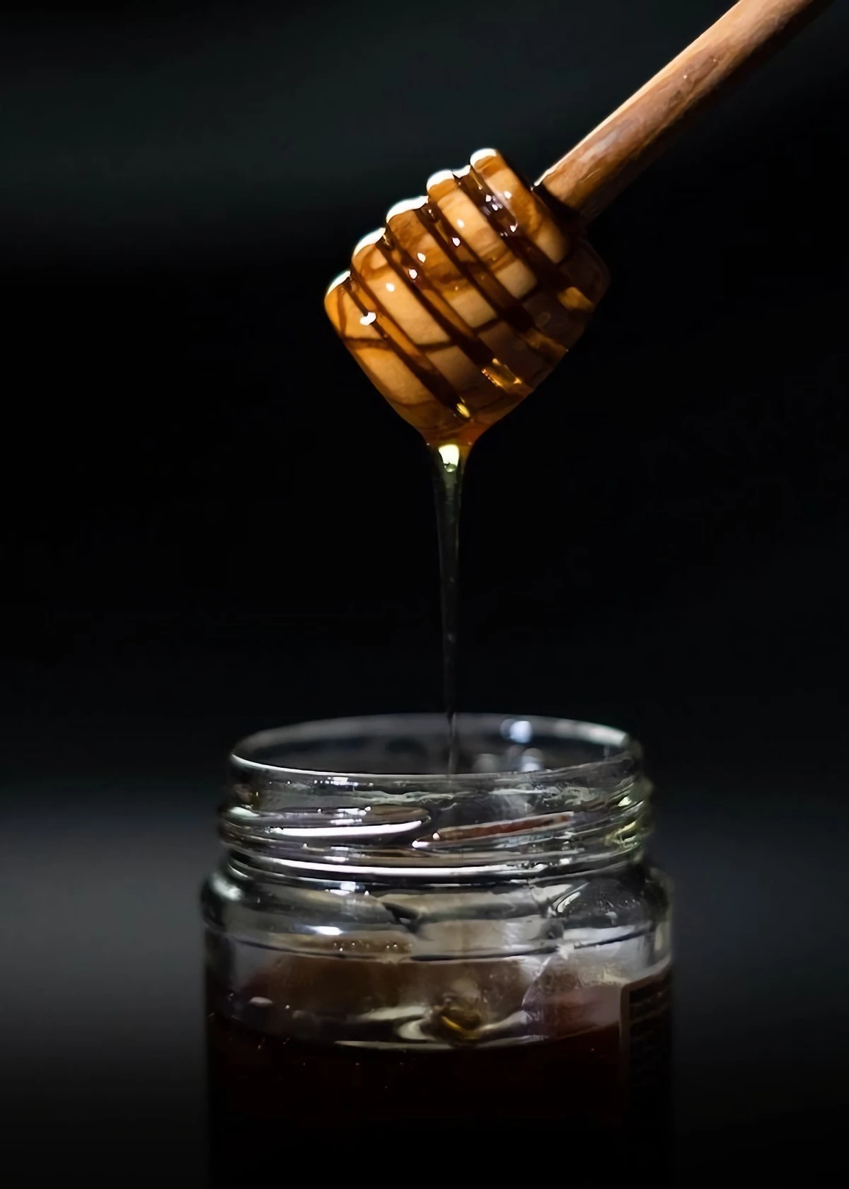 drizzling honey in a jar