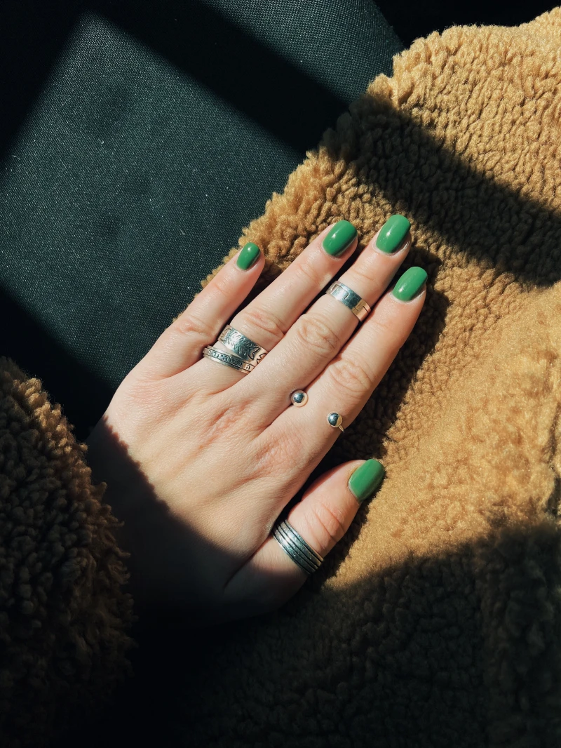 green nails on a flufffy blanket