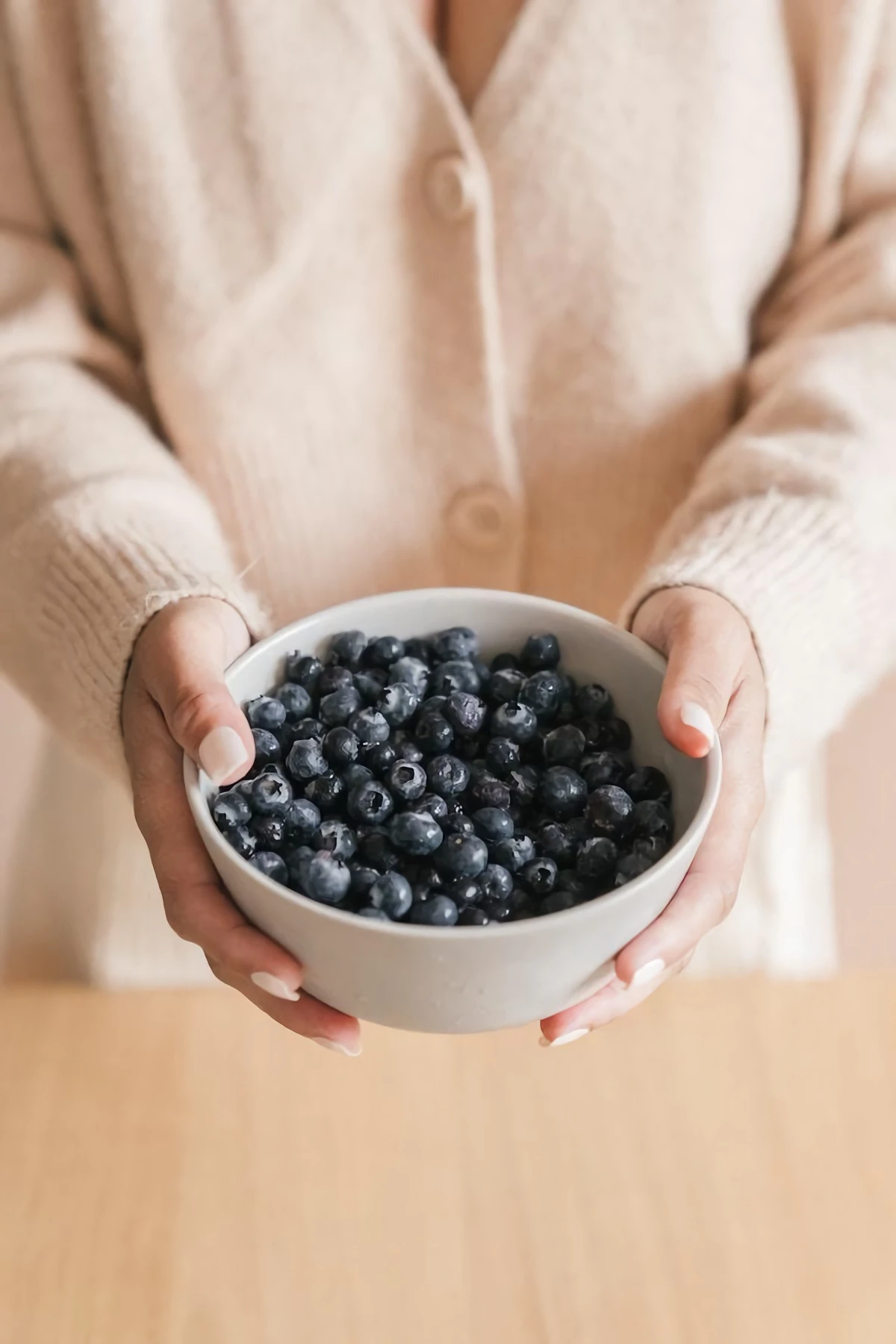 hands holding a bowl of berries