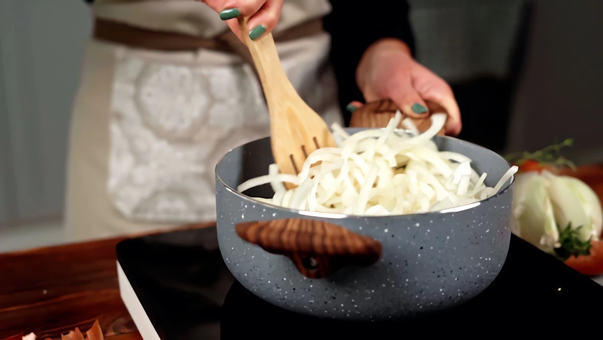 mixing onions with wooden spoon