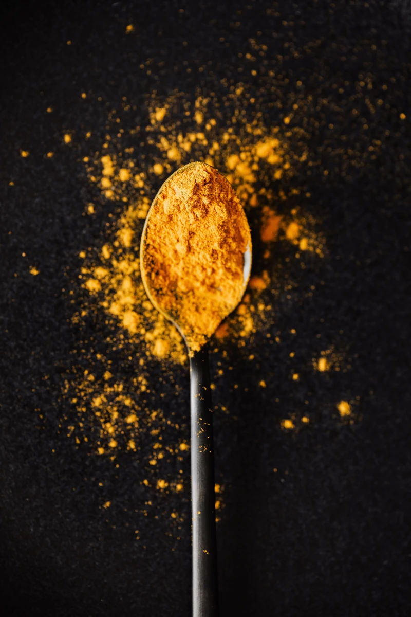 spoonful of turmeric on black background