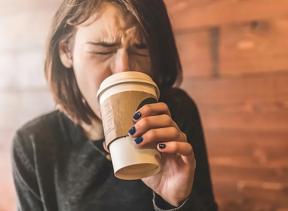 woman burning her tongue drinking coffee