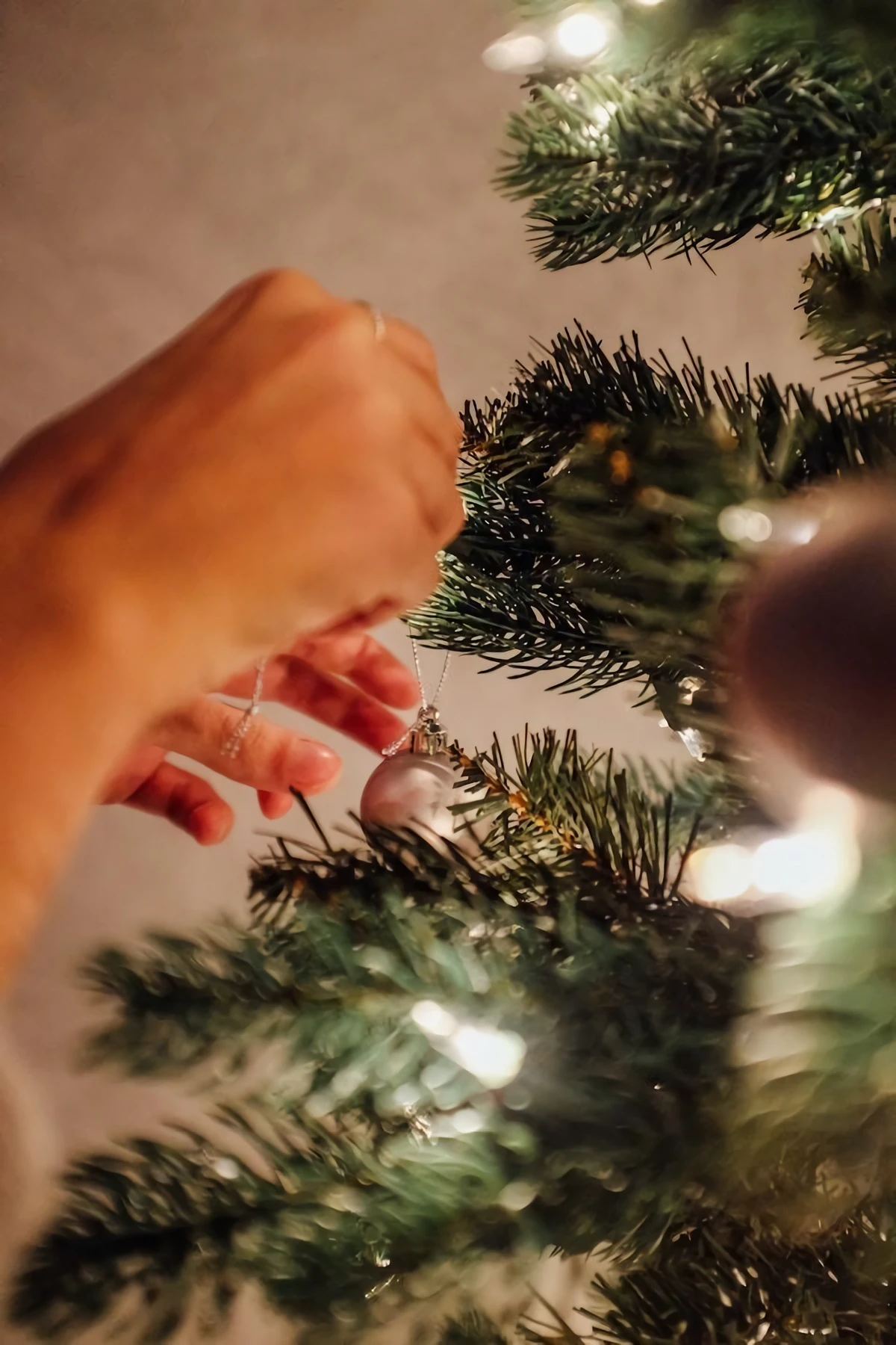woman putting an ornament on tree