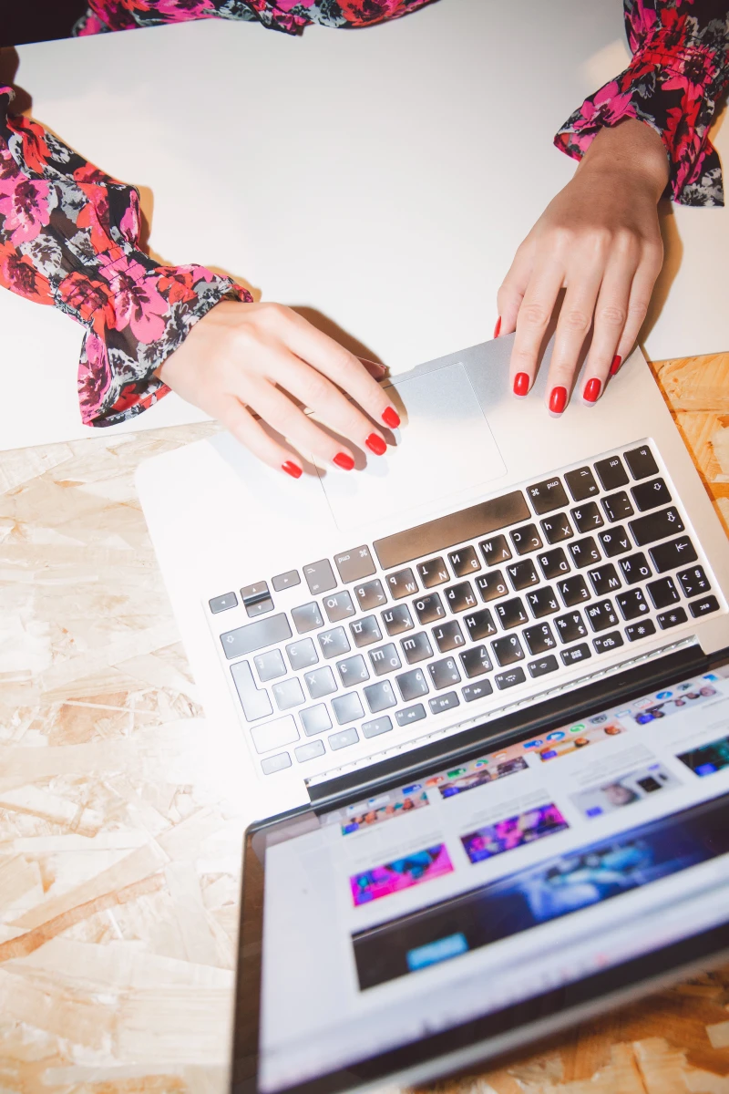 woman working on her computer with red nails