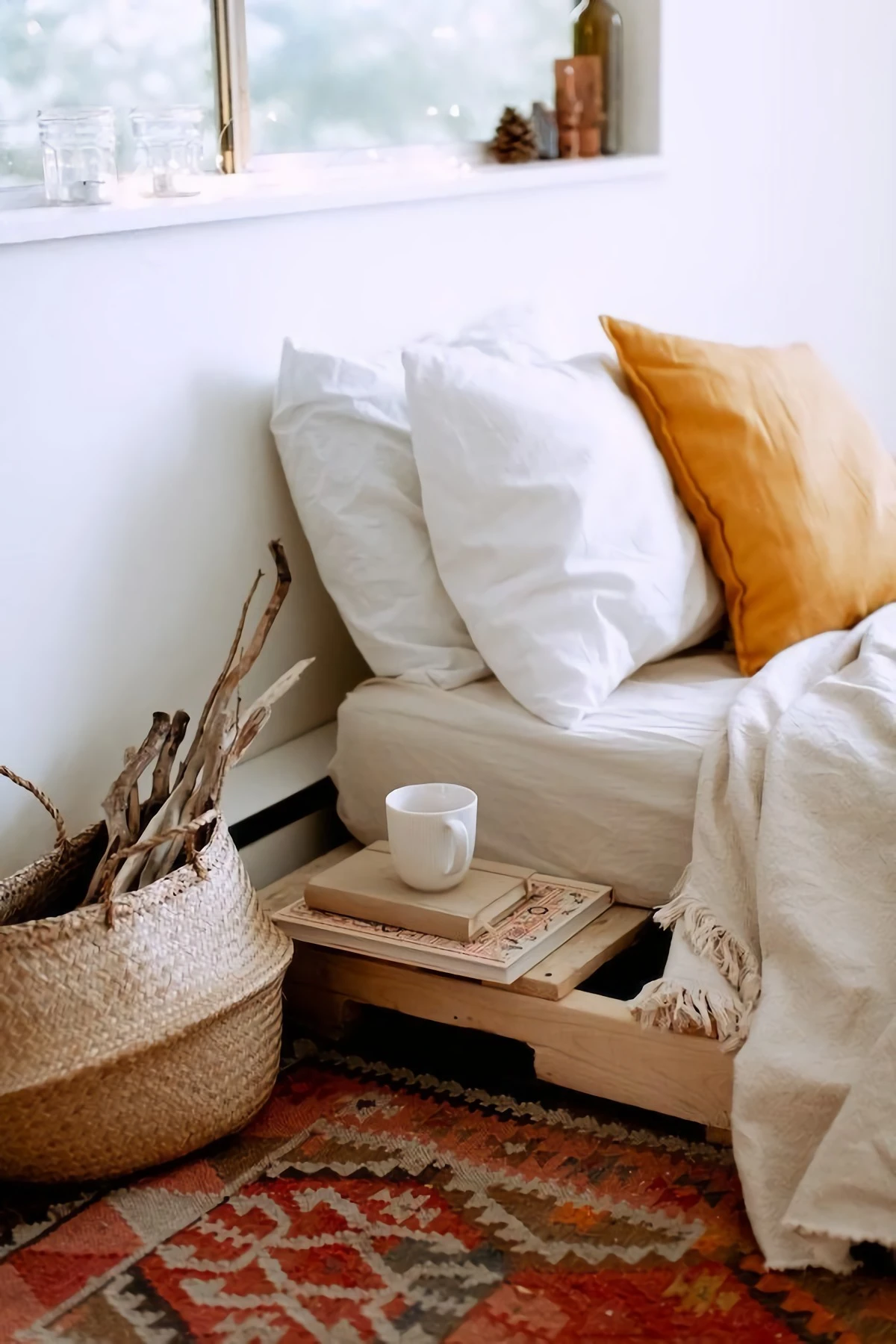 bed with two white and one orange pillow