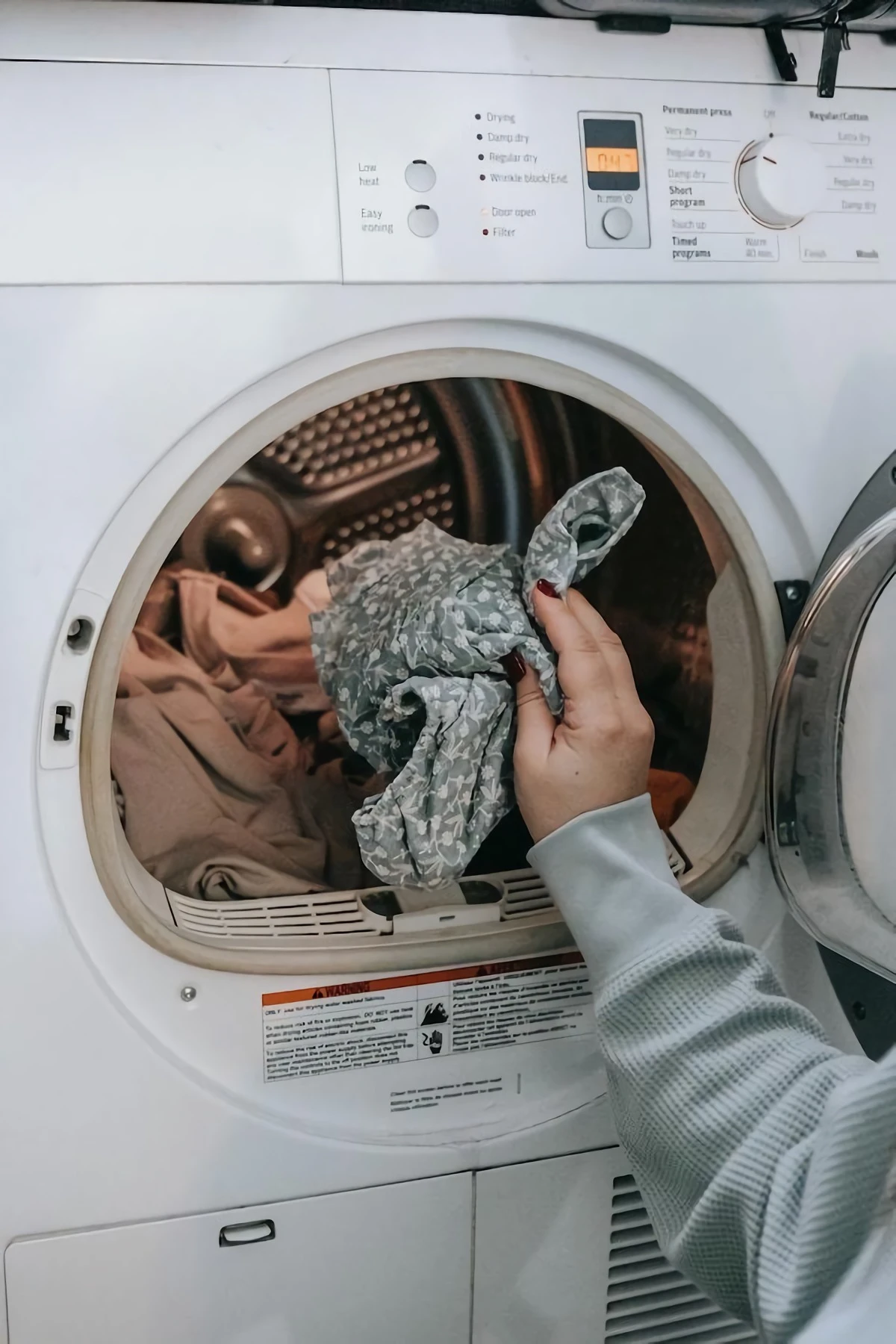 common laundry mistakes person throwing clothes in the machine