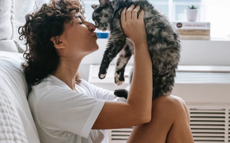 how do cats show affection woman holding her cat in the air