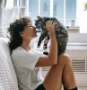 how do cats show affection woman holding her cat in the air